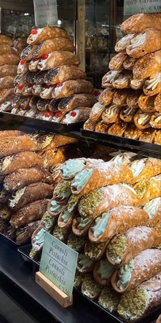 a display case filled with lots of different types of breads and pastries for sale