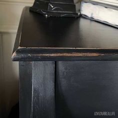 a black desk with an old clock on top