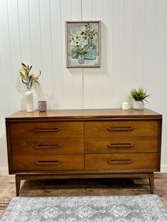 a large wooden dresser sitting on top of a hard wood floor next to a rug