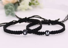 two black bracelets with white letters are sitting next to each other on a table