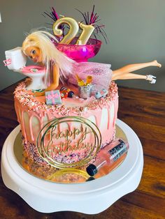 a birthday cake decorated with barbie dolls and decorations