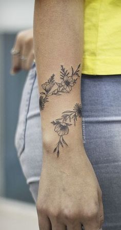 a woman's arm with flowers tattooed on it