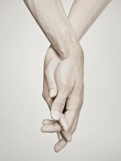 two hands holding each other in front of a white background