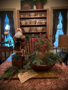 a santa clause figurine sitting on top of a table next to christmas decorations