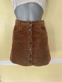 Casual Brown Corduroy Mini Skirt, Brown Corduroy Casual Mini Skirt, Fitted Brown Corduroy Mini Skirt, Brown Corduroy Mini Skirt For Fall, Brown Corduroy Bottoms With Buttons, Brown Mini Skirt With Button Closure, Brown Cotton Skirt With Buttons, Corduroy Mini Skirt With Button Closure, Brown Corduroy Bottoms With Button Closure