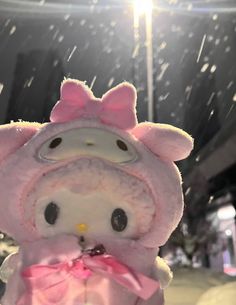 a hello kitty stuffed animal with a pink bow on it's head in the snow