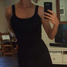 a woman taking a selfie in a black dress