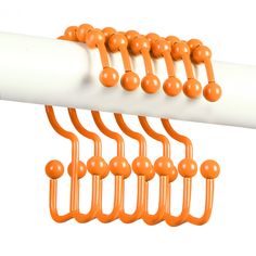 an orange and white wall mounted rack with balls on it's end, attached to a pipe