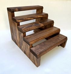 a set of three wooden steps sitting on top of a white floor next to each other