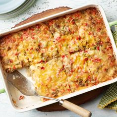 a casserole dish with meat and vegetables in it next to a spatula