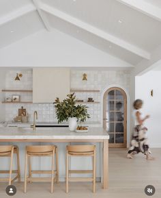 a kitchen with two stools and a center island in front of the countertop