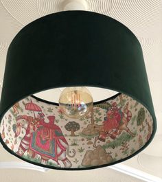 a black lamp shade hanging from the ceiling in a room with wallpaper on it