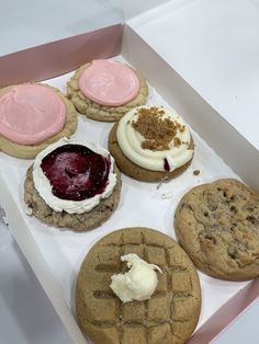 a box filled with cookies covered in frosting and toppings