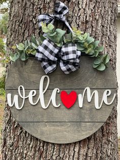 a welcome sign hanging on the side of a tree