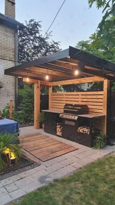 an outdoor bbq with lights on the roof and grilling area in the back yard