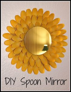 a yellow mirror hanging on the wall with words above it that read diy spoon mirror