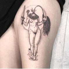 a woman's thigh with a tattoo on it and a knife in her hand