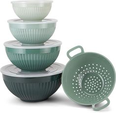 four bowls stacked on top of each other and one has a strainer in the middle