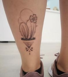 a woman's foot with a cactus tattoo on the left side of her leg