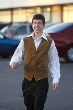 a man in a vest is walking down the street