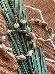 Elevate your beach vibes with our handcrafted cowrie shell hoop earrings. Each pair is meticulously crafted to exude bohemian charm and cultural elegance. These stunning earrings feature genuine cowrie shells delicately wire wrapped, creating a timeless accessory perfect for any occasion. Embrace your divine feminine energy with these versatile earrings, whether you're lounging by the shore or exploring the city streets. Add a touch of natural beauty to your look with these artisanal cowrie shel Handmade Dangle Hoop Earrings For Vacation, Shell Dangle Hoop Earrings For Beach, Handmade Bohemian Hoop Earrings For The Beach, Bohemian Small Hoop Earrings For Beach, Gold Beaded Hoop Earrings For The Beach, Handmade Cowrie Shell Earrings For Beach, Handmade Shell Hoop Earrings For Beach, Cowrie Shell Earrings For Beach, Bohemian Shell Hoop Earrings For Beach