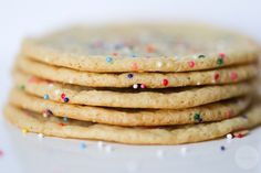 a stack of cookies with colorful sprinkles on them sitting on a white surface