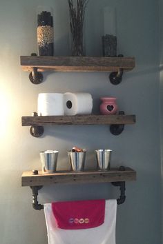 two wooden shelves holding toilet paper, cups and other items on top of each shelf