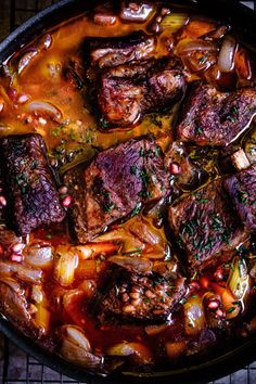 a pan filled with meat and vegetables on top of a table