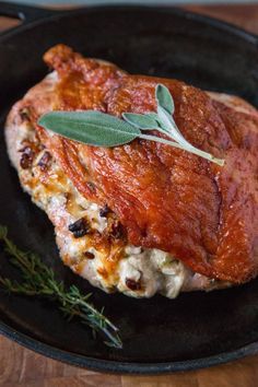 a piece of meat in a black pan on a wooden table