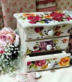 two drawers with flowers painted on them next to a bouquet of flowers and a teddy bear