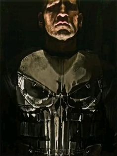 an image of a man in the dark with a skull on his chest and one eye open