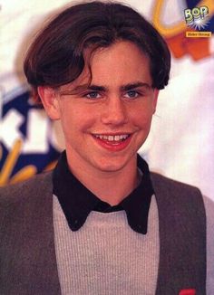 a young man wearing a bow tie and vest