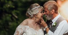 an older man and woman standing next to each other