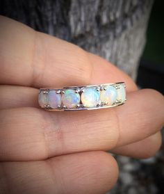 a person holding an opal ring in their hand