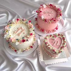 three heart shaped cakes on top of each other with the word love spelled in frosting