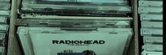 the radiohead records are stacked on top of each other