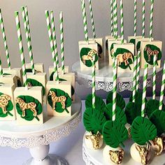 there are many green and white desserts on the table with straws in them