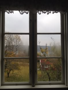 two open windows with the view of water and mountains in the distance at sunset or dawn