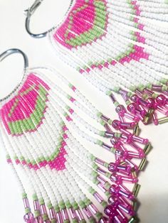 Cotton Candy Native American inspired fringe earrings. These earrings are stunning and sure to make a bold statement. Featured in hot pink, white, and neon green seed beads and pink and green bugle beads. These are dangle fringe earrings that create a lot of movement. Hand beaded onto a 2 in silver hoop and overall length is 4 inches. Pink Chandelier Earrings With Dangling Beads For Festival, Pink Beaded Fringe Jewelry For Festival, Pink Beaded Fringe Earrings For Party, Pink Beaded Tassel Earrings For Festival, Pink Fringe Beaded Earrings For Summer, Pink Beaded Earrings With Fringe, Summer Pink Beaded Fringe Tassel Earrings, Pink Tassel Earrings With Colorful Beads For Festivals, Pink Fringe Earrings For Festival