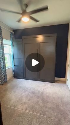 an empty living room with a ceiling fan and blue walls in the back ground area