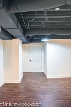 an empty room with hard wood floors and white walls