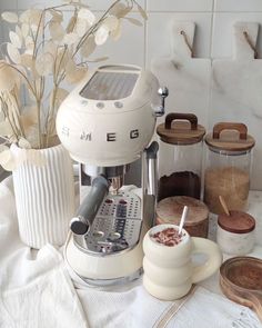 a coffee maker sitting on top of a counter next to some cups and saucers