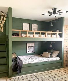 a bunk bed in a room with green walls and white pillows on the bottom bunk