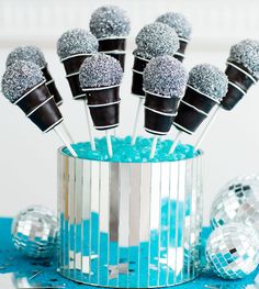 there are some silver and black cake pops in a cup