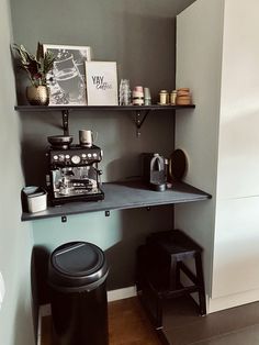 there is a coffee maker on the shelf in this small room with shelves and stools