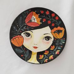 a decorative plate with a woman's face painted on the front and back side