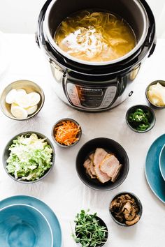 an assortment of food is placed in bowls around the crock pot and bowl on the table