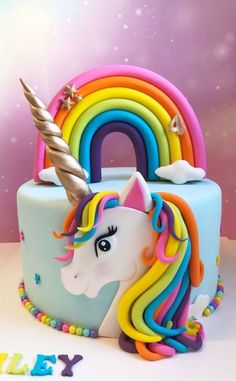 a birthday cake with a rainbow unicorn on top