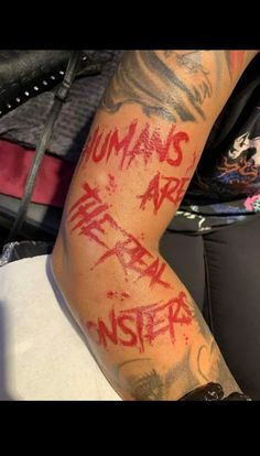 the arm is covered in red ink and has writing on it that says humans are never inside