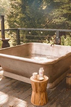 an old bathtub sitting on top of a wooden deck